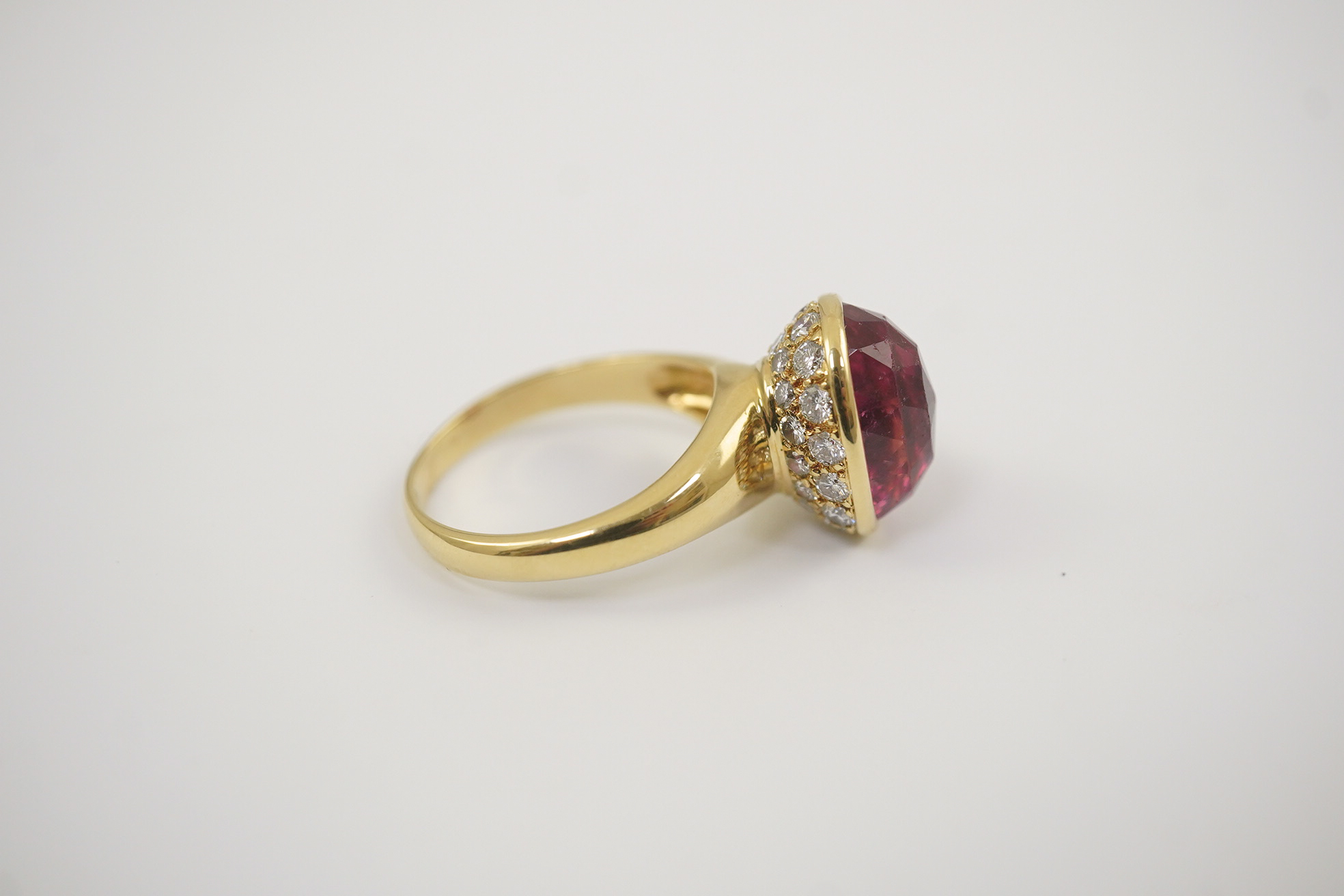 A modern 18k gold and single stone fancy oval cut deep pink tourmaline set dress ring, signed Asprey?